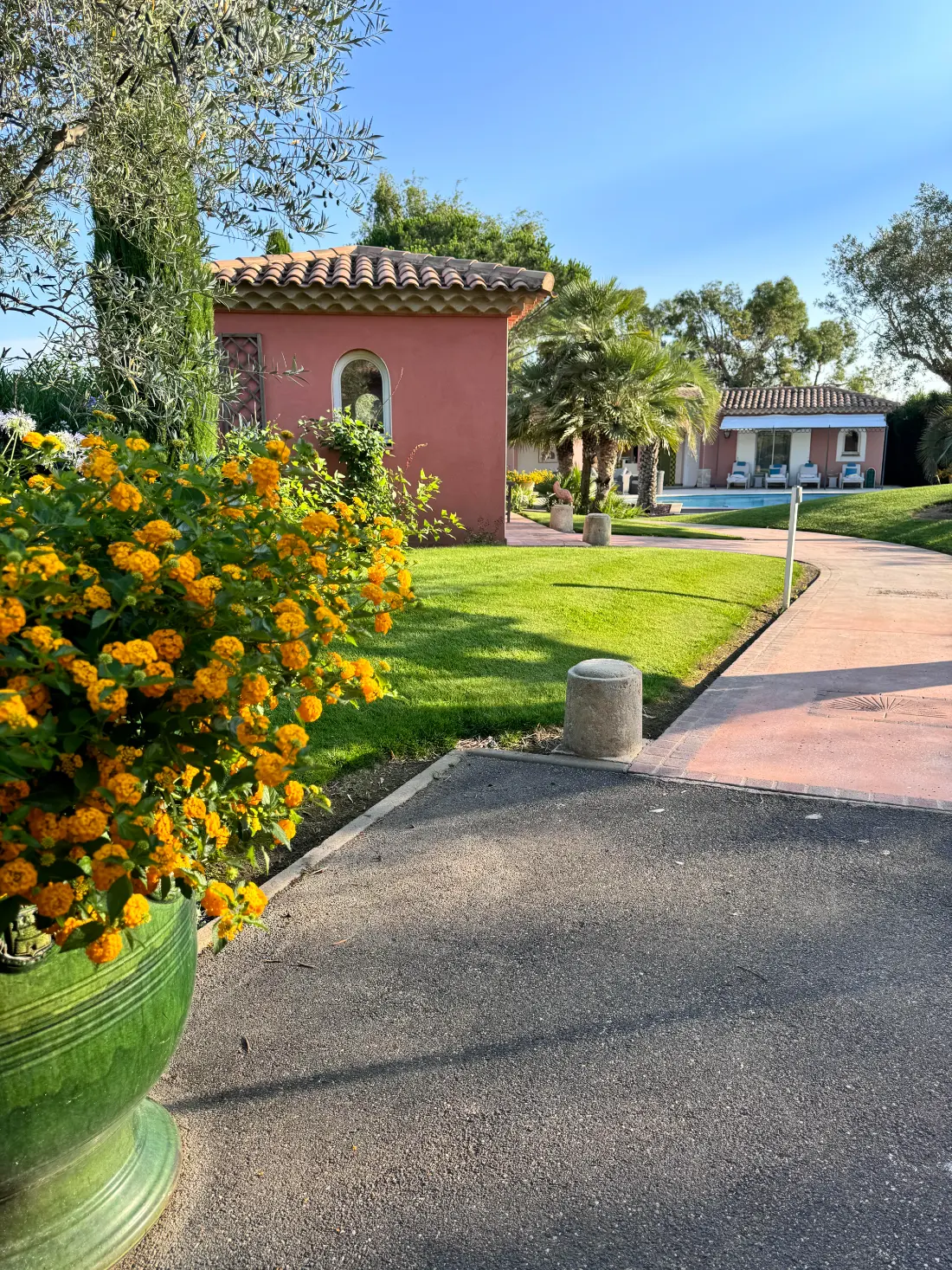 Jardin entretenu avec pelouse, allée et vasque de lantanas fleuris